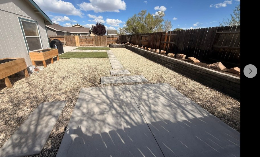 Backyard with new concrete patio, stone retaining wall and desert gravel landscaping in Fernley Nevada